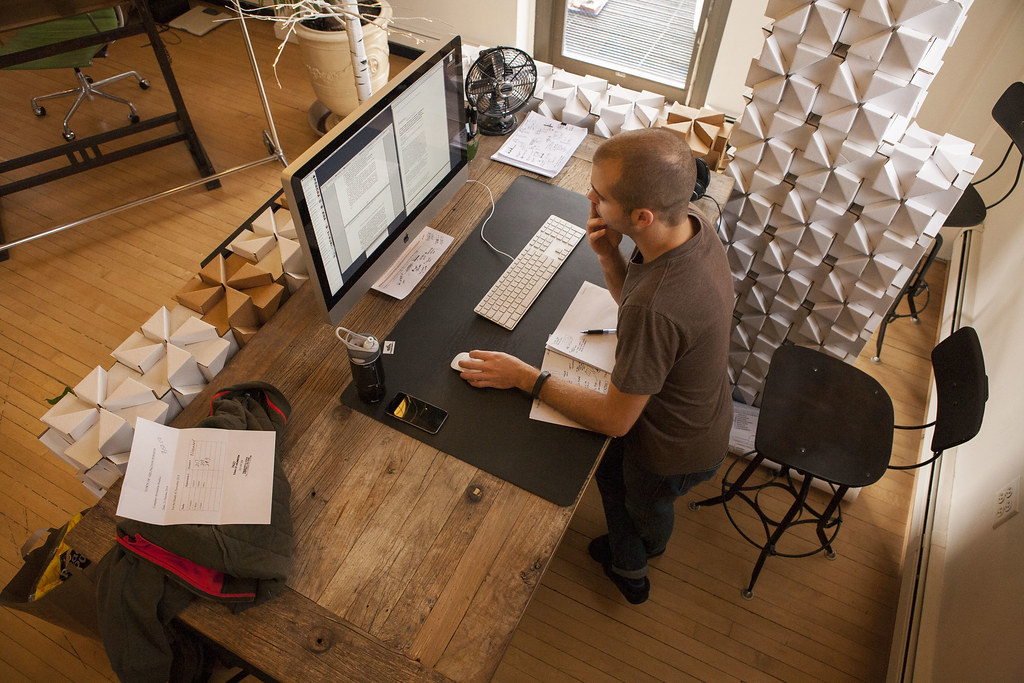 Designer reviewing layout notes at a studio desk while working on a website project